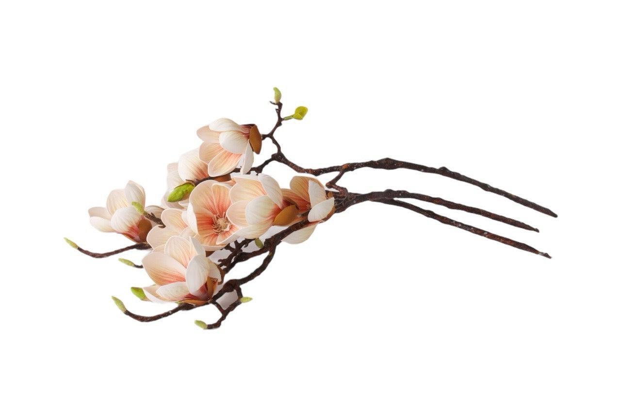 3 takken kunstbloem magnolia met diverse bloemen en knoppen in de kleur zacht roze liggend gefotografeerd