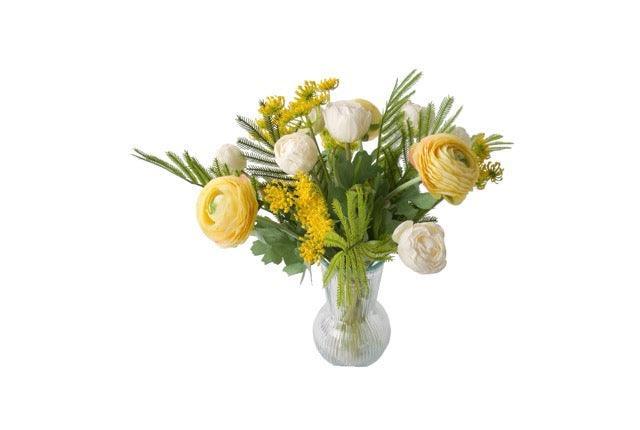 productfoto van een Frisse Voorjaars Kunstbloemen gebonden in Geel met Wit met Tulpen wit, Fluitekruid geel, Ranonkel Geel, Tak Mimosa op een glas vaas van helder glas