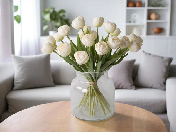 Boeket witte kunsttulpen  in een heldere glasvaas op een houten tafel in een kamer - Winq