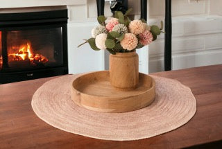 Kom acaciahout 35cm met een vaas van acaciahout en een kunstbloemen boeket met dahlia op een tafel voor een haard