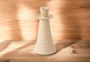 Metalen kandelaar met een ruwe finish voor een dinerkaars in off white 11x21cm op een houten tafel