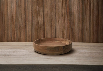 Kom van acaciahout , diameter 35cm en een rand van 6cm op een tafel voor een muur