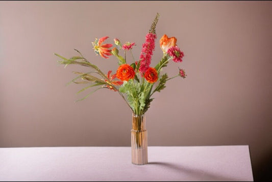 Kunstbloemen Veldboeket Bloemen Rood/ Pink/ Oranje inclusief vaas op een witte tafel voor een lichte bruine muur
