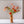 Veldboeket Zijden Bloemen Rood/ Roze/ Oranje inclusief vaas op een witte tafel met een witte en bruine muur