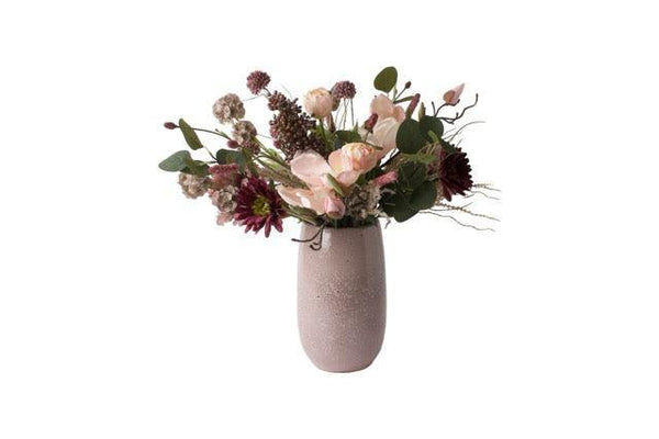 Gebonden kunstbloemen op een keramieken mauve kleurige vaas Het boeket is in een paars Roze kleurencombinatie met onder andere tulpen en gerbera en eucalyptus.