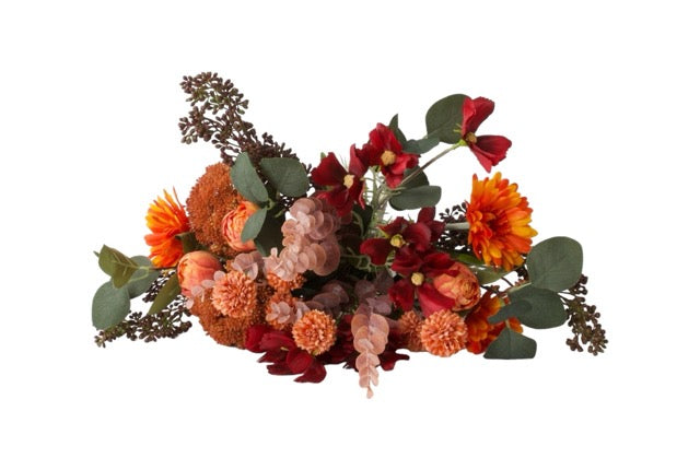 Boeket kunstbloemen in de kleur rood en oranje met onder andere Tulp, Cosmea, Schermbes en Gerbera liggend gefotografeerd