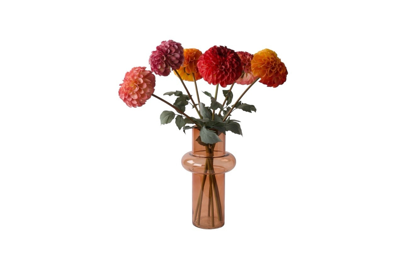 Boeket zijden dahlia's in de kleuren rood oranje mauve en pink in licht roze glas vaas 