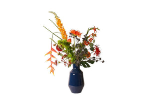 Veldboeket met kunstbloemen met diverse bloemen waaronder distel en ranonkel  op een blauwe hoogglans metalen vaas