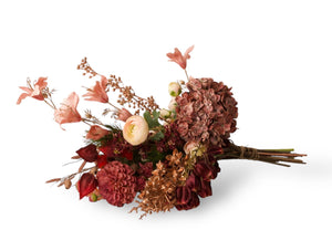 Boeket kunstbloemen liggend gefotografeerd bestaande uit diverse bloemen in de kleuren oud royement hortensia dahlia , magnolia en anderen