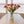 Boeket kunsttulpen  in de kleuren rood, mauve en warm oranje in een glasvaas op een houten tafel voor een raam - WinQ