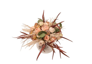 Kort gebonden boeket van kunstbloemen bestaande uit rozen in roze, mauve en rood gepresenteerd op een ronde glasvaas - WinQ