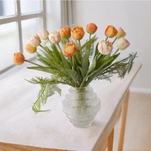 Oranje en roze tulpen in een glasvaas op een tafel voor het raam -  WinQ