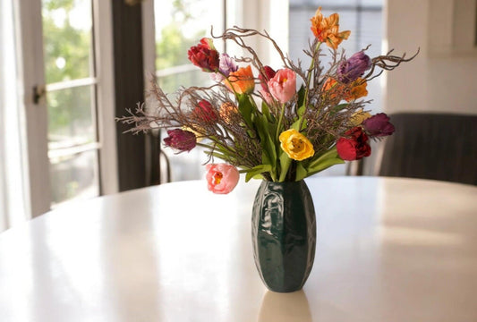 Mooi boeket Kunstbloemen op een tafel met diverse soorten kunsttulpen in diverse kleuren, rood, oranje, paarse, lila op een groene vaas gebonden met decoratieve takken - WinQ