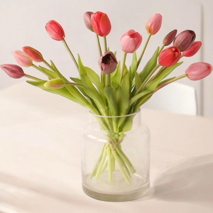 15 kunst tulpen op een glasvaas in de kleuren fuchsia, pink, mauve op een lichte houten tafel voor een lichte muur - WinQ