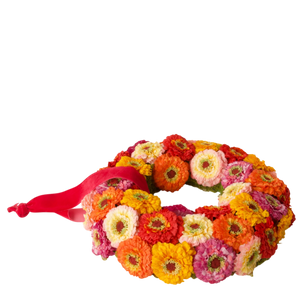 Kunstbloemenkrans met kleurrijke zinnia bloemen en rood lint, decoratie voor interieur
