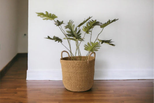 Plantenmand Abaca Handvat Naturel 33x29cm met palm op houten vloer voor een witte muur