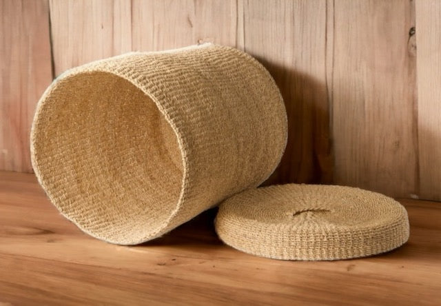 Abaca mand liggend op een houten vloer met een deksel ernaast