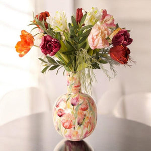 Diverse soorten tulpen in multicolor  met diverse groen gebonden op een gebloemde vaas op een tafel-WinQ