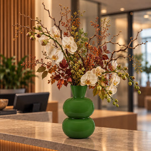 ronde bollen vaas van metaal in hoogglans groen met kunstbloemen op een kantoorbalie - WinQ