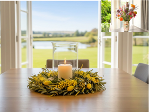 laurierkrans met gele voorjaarsbloemen zoals tulpen op een tafel met een kaars - WinQ