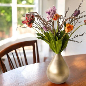 Gouden vaas met papagaai kunsttulpen in rood, oranje, lila en paars gebonden met verschillende twijgen in een gouden vaas op een houten tafel - WinQ