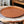 Koperschaal met kiezelsteen gravering in de kleur koper diameter 30cm op een houten tafel