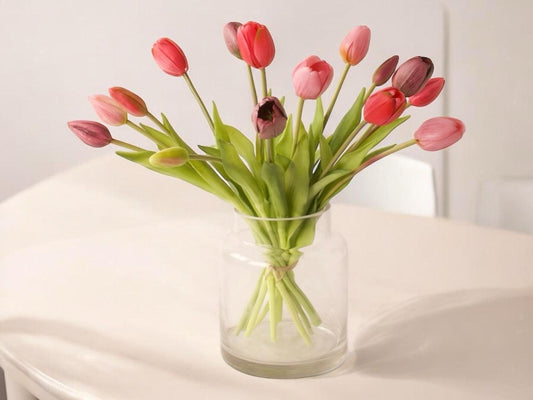 15 kunst tulpen op een glasvaas in de kleuren fuchsia, pink, mauve op een lichte houten tafel voor een lichte muur - WinQ
