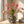 sfeerfoto Vaas celestial met dieren en bloemenprint met basis petrol en diverse kleuren geel groen en roze opgemaakt met boeket in rood met papaver - WInQ