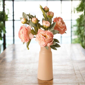 Sfeerfoto van een vaas met 3 takken kunst pioenrozen met meerder bloemen in de kleur oud roze gefotografeerd in een serre op een houten tafel- WInQ