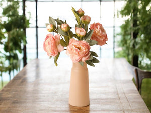 Sfeerfoto van een vaas met 3 takken kunst pioenrozen met meerder bloemen in de kleur oud roze gefotografeerd in een serre op een houten tafel- WInQ