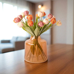 Oranje vaas met 21  tulpen in de kleuren roze oranje mauve op een houten tafel in een woonkamer - WinQ