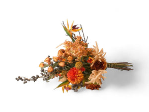 Boeket kunstbloemen liggend gefotografeerd, boeket gebondenmet diverse bloemen in najaarskleuren met onder ander dahlia en pompoenen