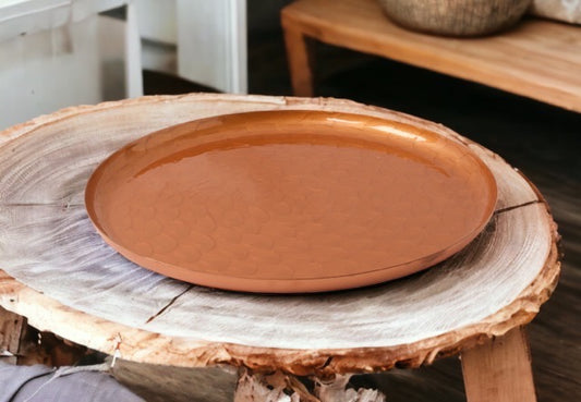 Koperschaal met kiezelsteen gravering in de kleur koper diameter 30cm op een houten tafel