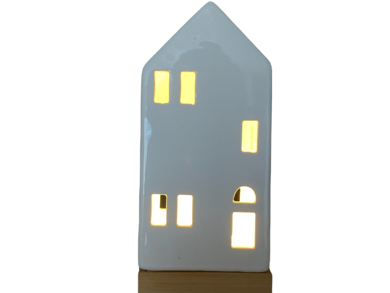 Kersthuisje van porselein op een houten voet met een brandend lampje