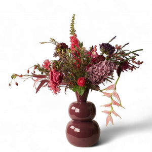 kunstboeket van kunstbloemen in blauw lila en roze  op een rode metalen vaas - Winq