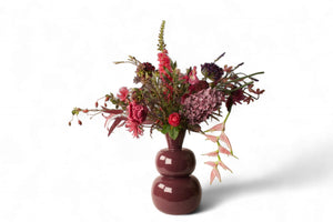 kunstboeket van kunstbloemen in blauw lila en roze  op een rode metalen vaas - Winq