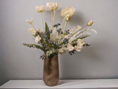 Veldboeket van zijde bloemen bestaande uit een wit goren kleuren combinatie met papaver dahlia en groen accenten op een bruine glasvaas gepresenteerd op een tafel