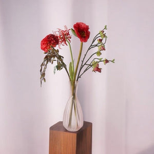 Moederdag boeket in de kleur rood op een zacht roze vaas op een houten zuil met de volgende kunstbloemenHibiscus Nerine Rood Papaver rood Dahlia Rood Chasmantia 