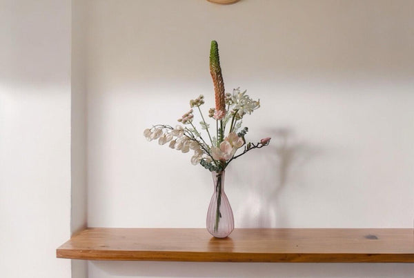 Plukboeket van Kunstbloemen zacht Roze.Physalis wit Magnolia zacht roze Eremures zacht roze Nerine wit Fluitekruid Roze Eucalyptus frosted op een houttafel voor een lichte muur