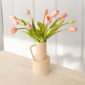 roze kunsttulpen op een licht houten tafel in een metalen vaas gefotografeerd op een lichte tafel - WinQ