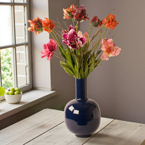 sfeerfoto van gbonden boeket met pioen en parrot tulpen in roze en rood tinten op een zwarte metalen vaas - WinQ