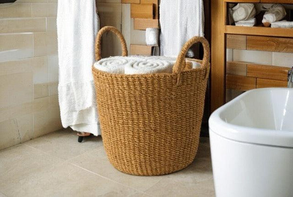 Wasmand Abaca Handvat Beige 33x29cm met opgerolde witte handdoeken in een bedkamer